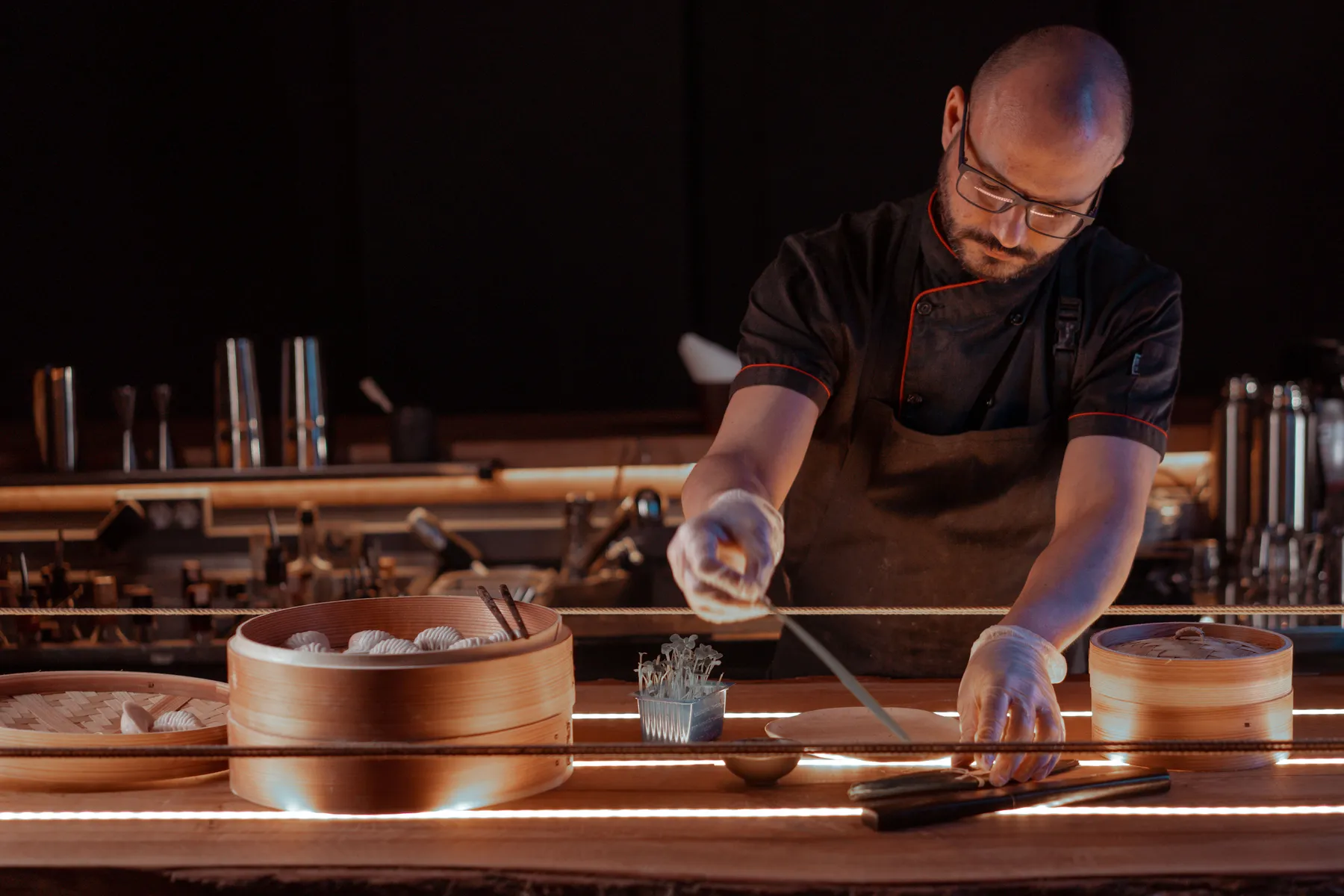Chef at a dark wooden counter